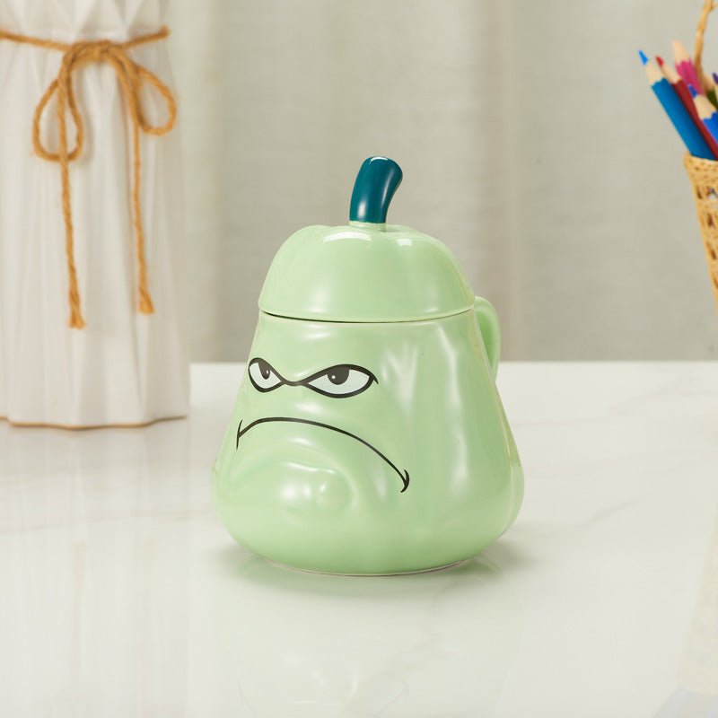 Green Grumpy Face Ceramic Mug with Lid - Displayed on a Table