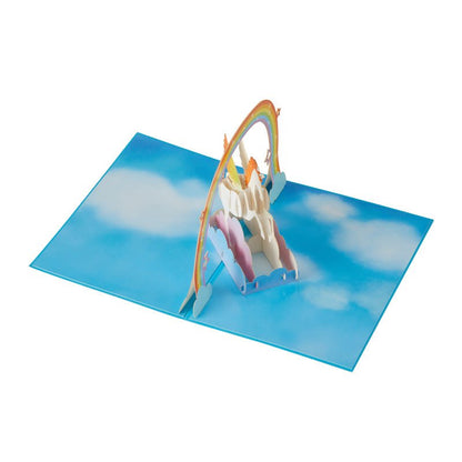 3D Pop-Up Unicorn Greeting Card with Rainbow and Clouds opened on a sky-blue background
