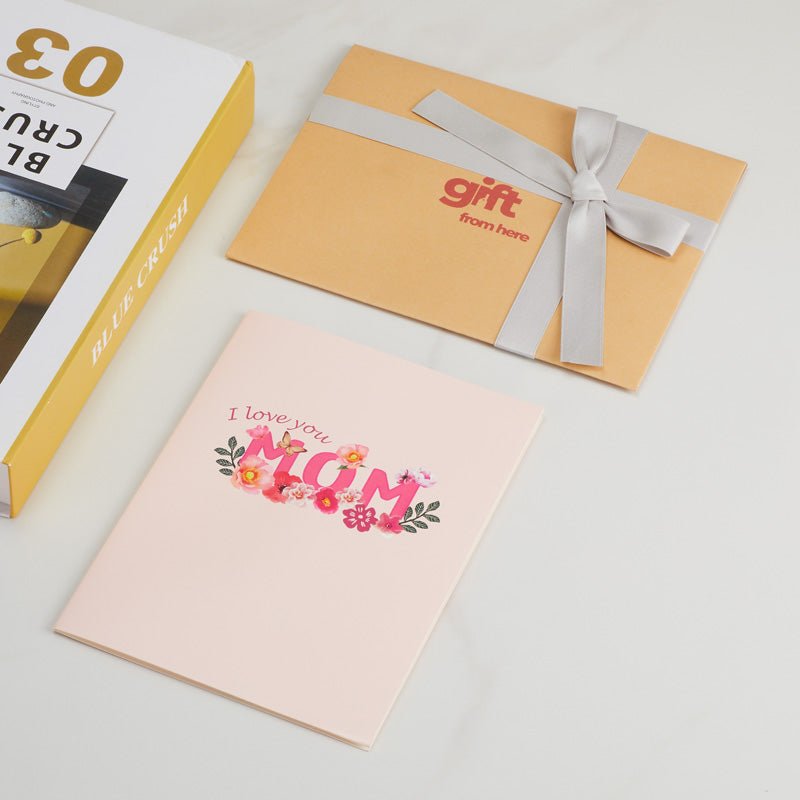 3D Pop-Up Mother's Day Greeting Card with a pink cover featuring 'I Love You Mom' text, alongside gift packaging