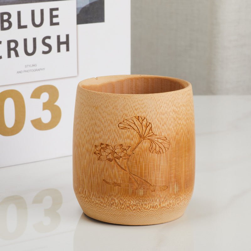 Handcrafted bamboo cup with an engraved lotus design, front view