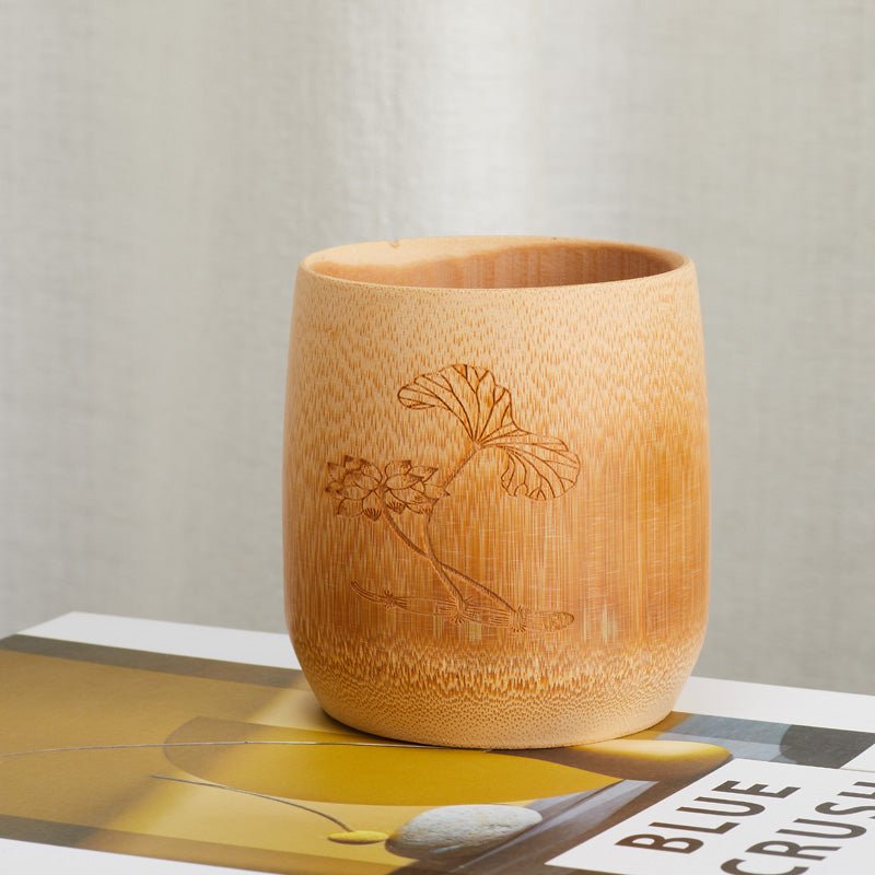 Handcrafted bamboo cup with an engraved lotus design, front view