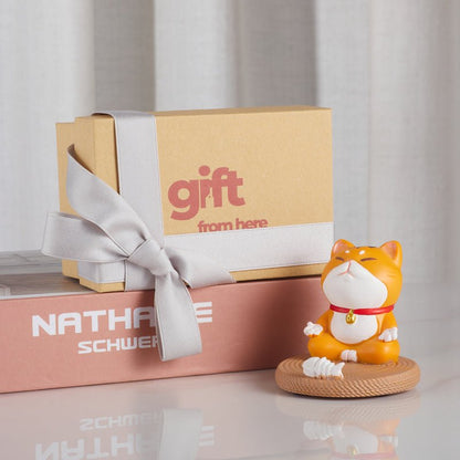 Gift box with meditating cat phone holder figurine next to it