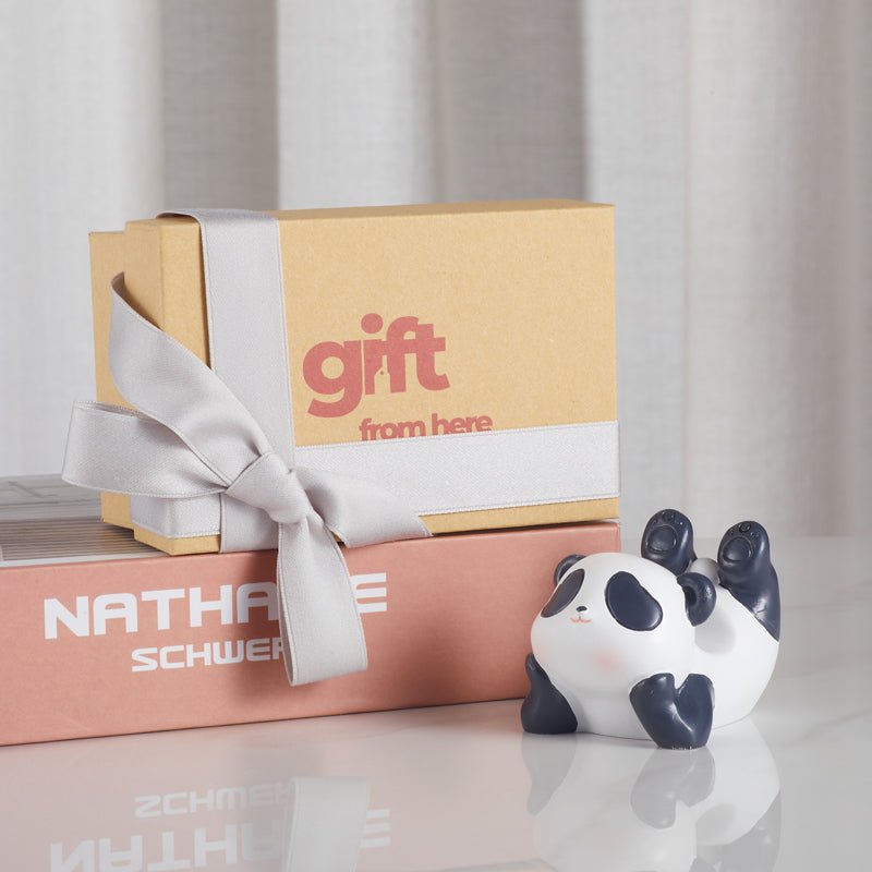 A cute panda phone holder displayed next to a gift box with a silver ribbon