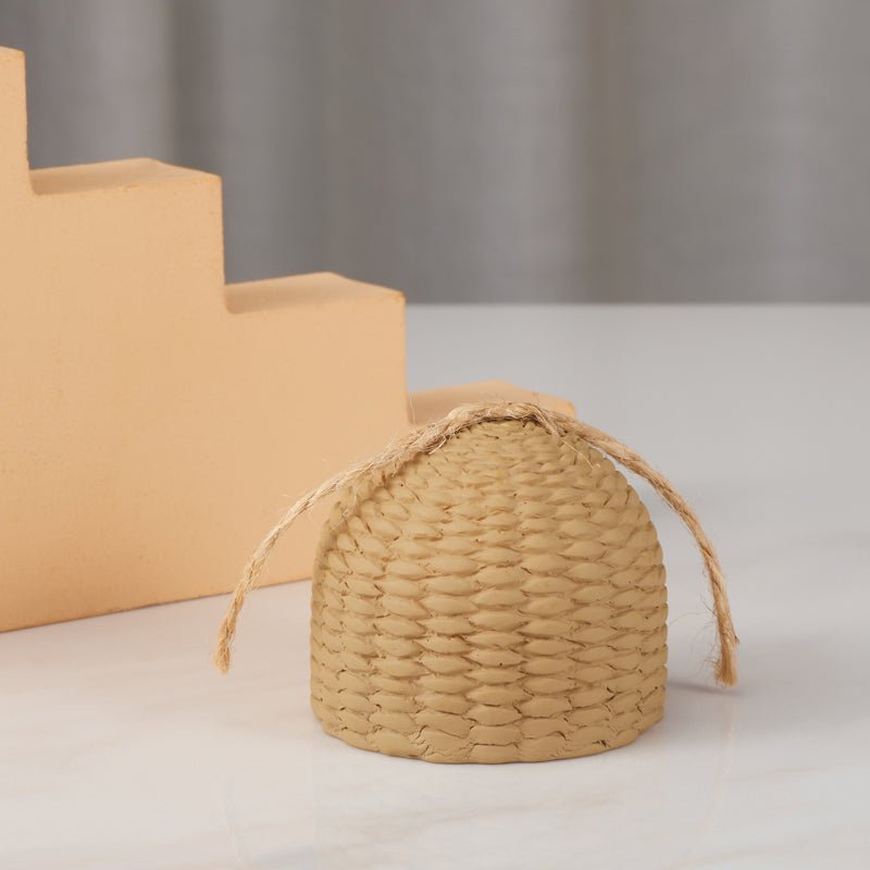 Back view of the small straw hut ornament on a white table