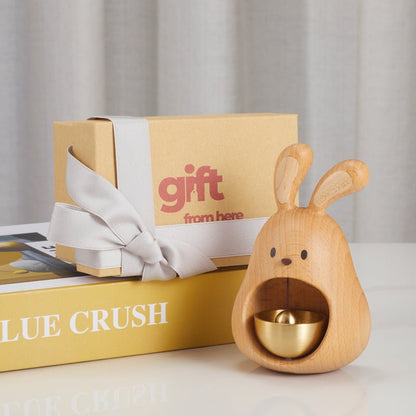 Gift box with a wooden rabbit bell and a silver ribbon