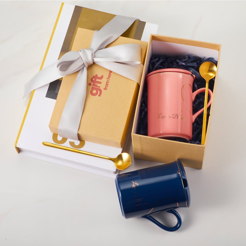 Gift box with Love is Beauty ceramic mugs in blue and pink with gold spoons