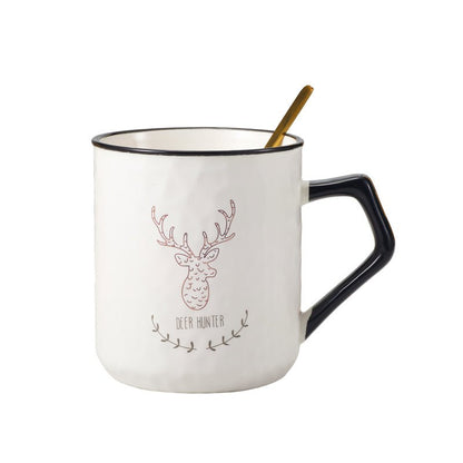 Ceramic mug with deer design and gold spoon