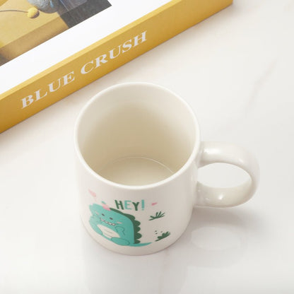 showing top view of white ceramic mug with cute dinosaur illustration