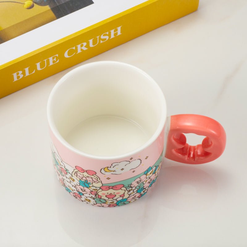 Top view of a ceramic mug with a pink floral design and a coral-colored floral-shaped handle